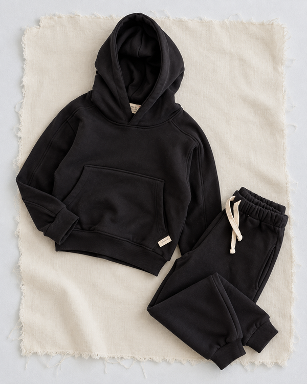 RG Brand RG1786 siyah çocuk kapüşonlu eşofman takımı, 3–9 yaş; üst ve pantolonun ayrı yerleşimi.