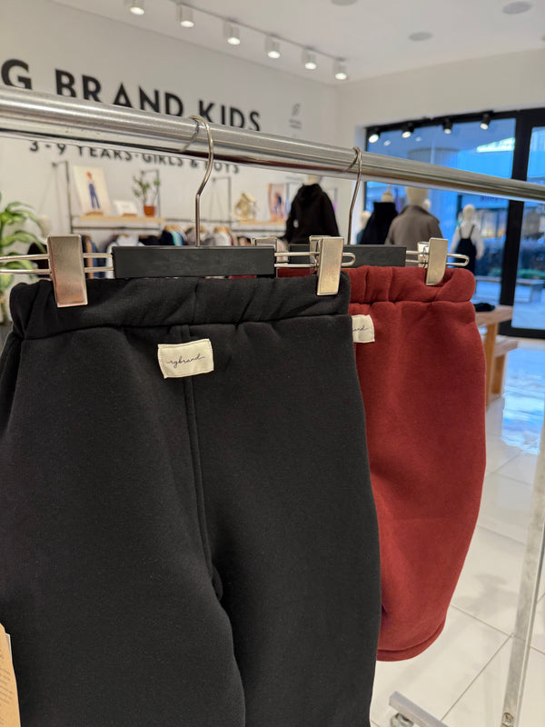 RG Brand Kids mağazasında askıda siyah ve bordo bebek eşofman pantolonların arka görünümü | RG404