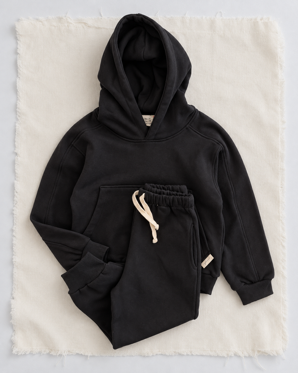 RG Brand RG1786 siyah çocuk kapüşonlu eşofman takımı, 3–9 yaş; üst ve pantolonun birlikte görünümü.