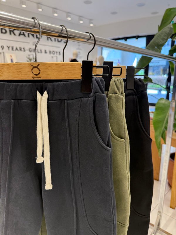 RG Brand Kids mağazasında askıda lacivert, yeşil ve siyah kavisli cepli jogger pantolonlar | RG1790