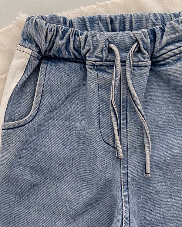 RG1792 mavi kot pantolonun yakın detayı; lastikli bel, kordon, kavisli ön cep, beyaz yan şerit ve denim dokusu.