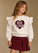 RG1793 ekru Big Love kalp baskılı, omuzları fırfırlı kız çocuk sweatshirt; model üzerinde ön görünüm.
