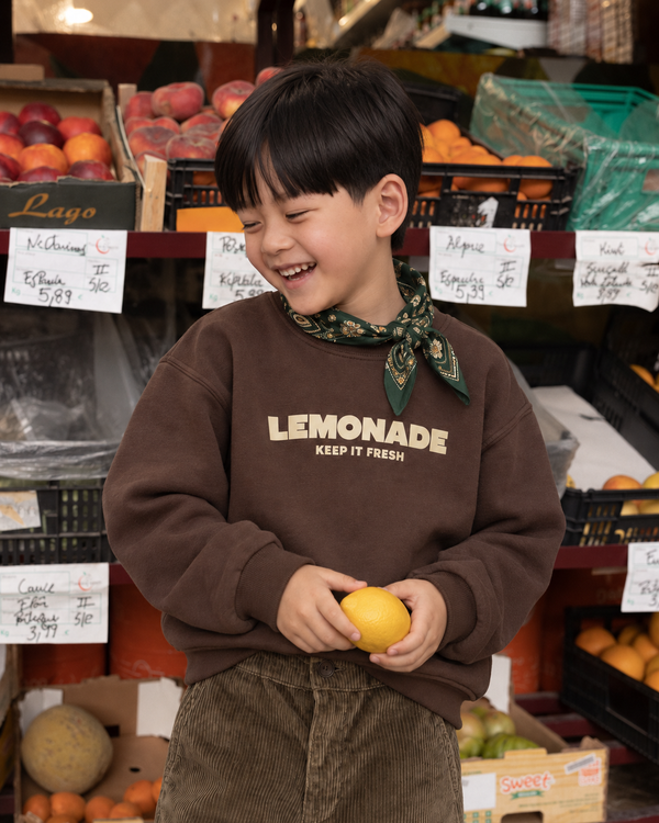 RG Brand RG1805 bordo mürdüm çocuk sweatshirtün bej Lemonade Keep It Fresh baskısı ve kumaş dokusu; gülerken yakın çekim.
