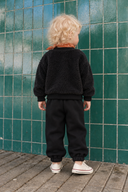 Back view of the RG356 black baby two-piece set on a child: plush sweatshirt and loose-fitting joggers with elasticated ankles.