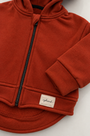 Kiremit kapüşonlu hırkada siyah fermuar, ribanalı manşet ve RG Brand etiket yakın detayı | RG403