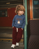 İndigo RG405 Milk figürlü çocuk sweatshirt, metro direği yanında önden görünüm